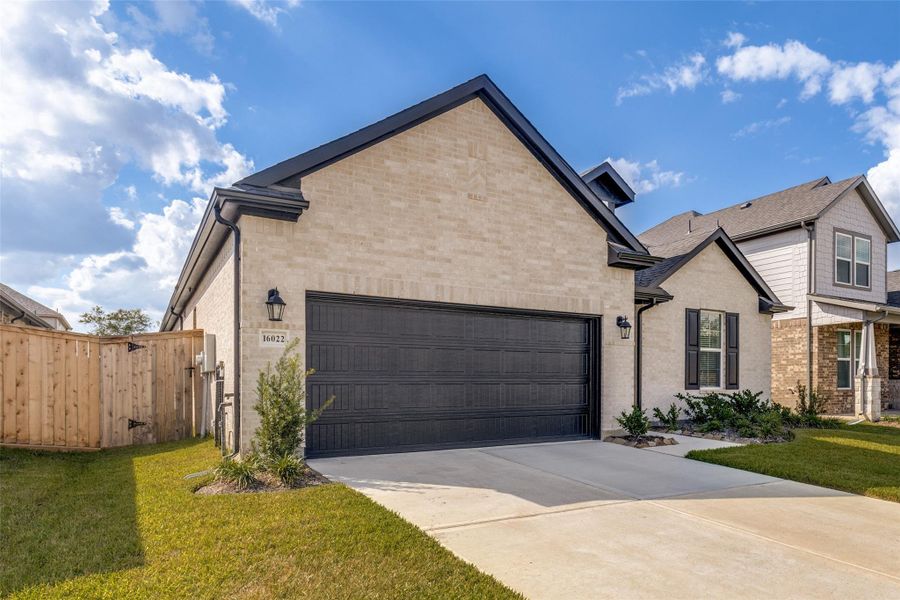 Front exterior of a new home in Mavera, Conroe, TX, highlighting curb appeal (Image 1).