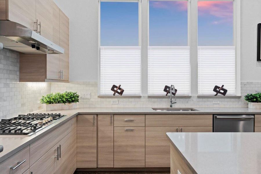 Kitchen featuring under cabinet range hood, light stone countertops, and modern cabinets