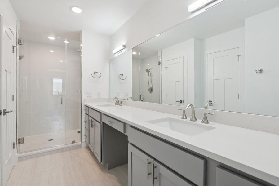 Full bath featuring double vanity, a stall shower, and recessed lighting
