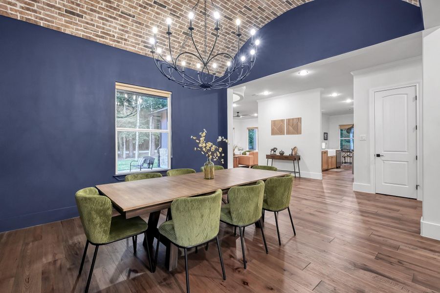 This elegant dining area, located opposite the kitchen, is ideal for entertaining and the modern chandelier enhances the sophisticated ambiance.