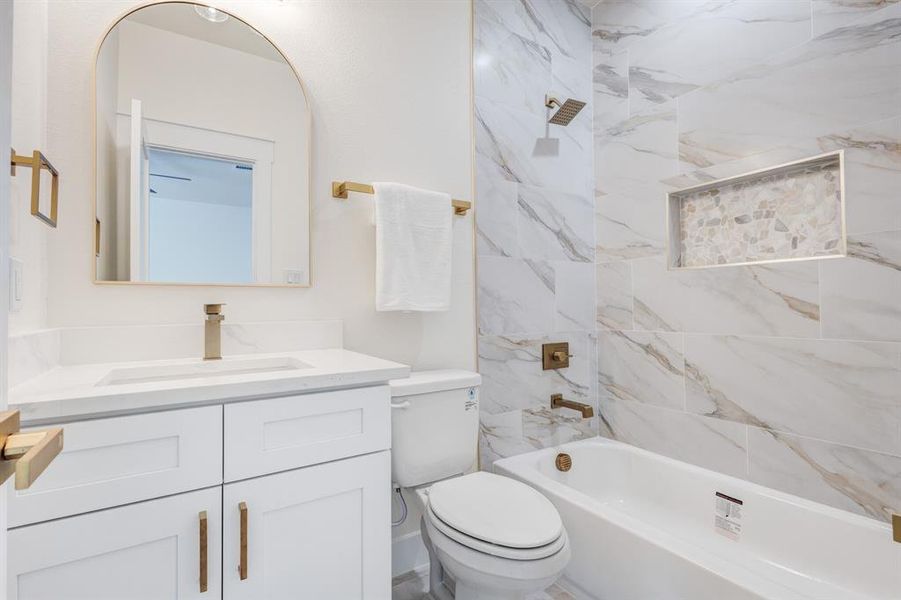 Full bathroom featuring tiled shower / bath, oversized vanity, and toilet