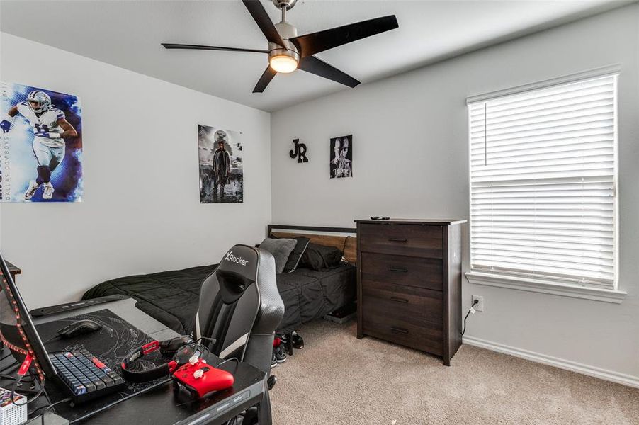Carpeted bedroom with  a ceiling fan