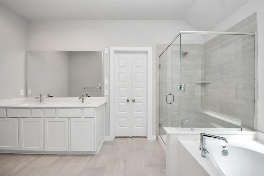Elevate your daily routine at the elegant vanity, now equipped with double sinks, light countertops, modern hardware, and beautiful recessed lights. Sample photo of completed home with similar floor plan. Actual colors and selections may vary.