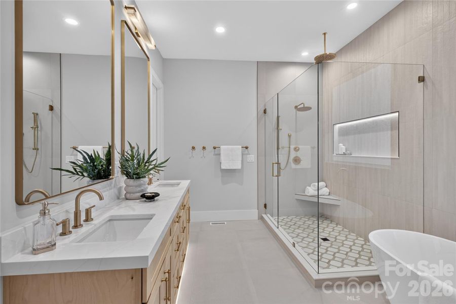 Primary bath! Notice the toe kick & shower niche lighting..one of my favorite features found throughout the home!