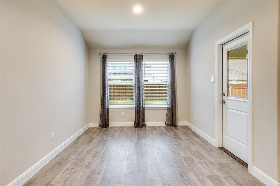 Spare room with light wood-style flooring and lofted ceiling Spare room with light wood-style flooring and lofted ceiling