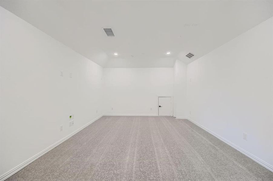 Spacious room featuring neutral carpeting, white painted walls, recessed lighting, and a white baseboard trim Spacious room featuring neutral carpeting, white painted walls, recessed lighting, and a white baseboard trim