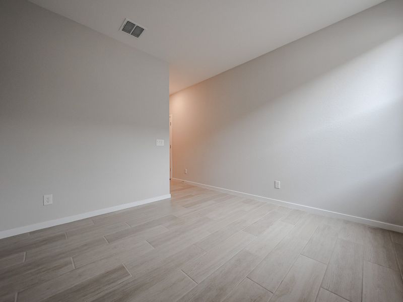 A room with a wood floor and a white wall.