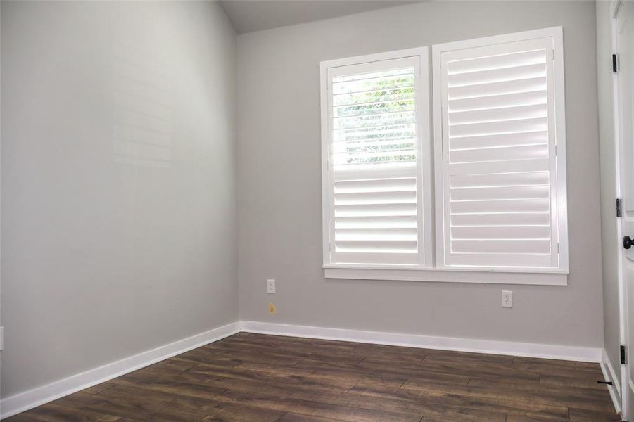 Empty room with baseboards and dark wood finished floors