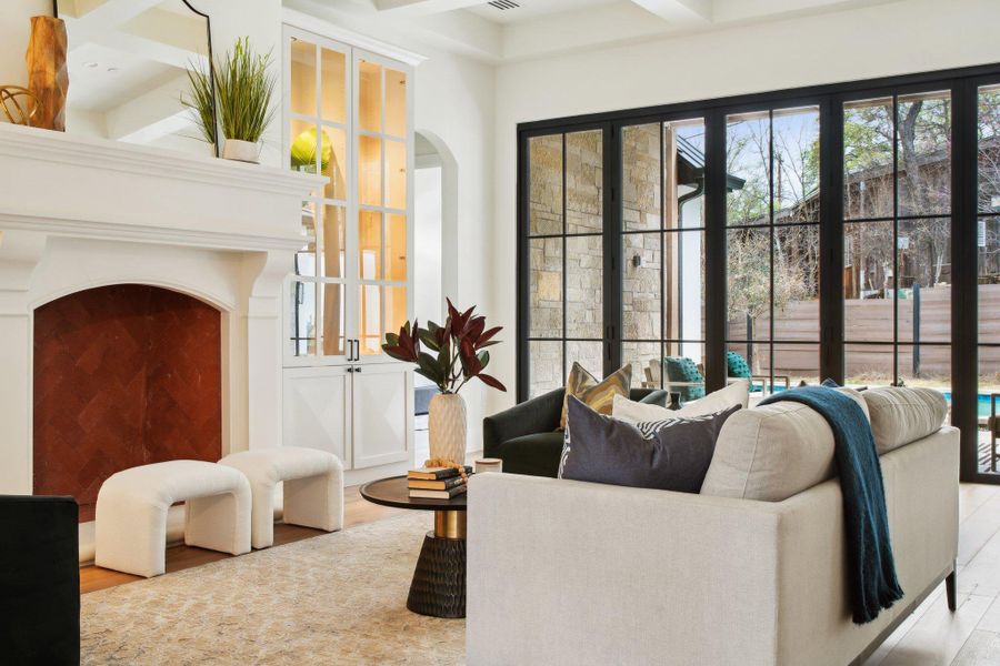 Living room featuring arched walkways, beam ceiling, and wood finished floors