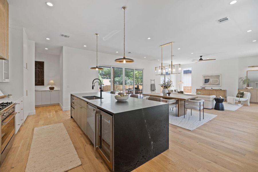 Kitchen featuring a large island with sink, open floor plan, pendant lighting, modern cabinets, and recessed lighting Kitchen featuring a large island with sink, open floor plan, pendant lighting, modern cabinets, and recessed lighting