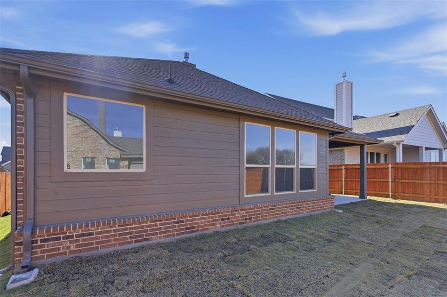 Back of house with roof with shingles, a chimney, and a patio Back of house with roof with shingles, a chimney, and a patio