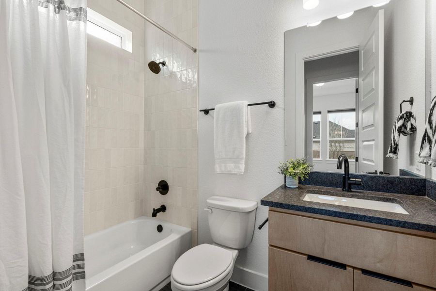 A well-appointed bathroom features modern fixtures, tiled walls, and practical vanity space.