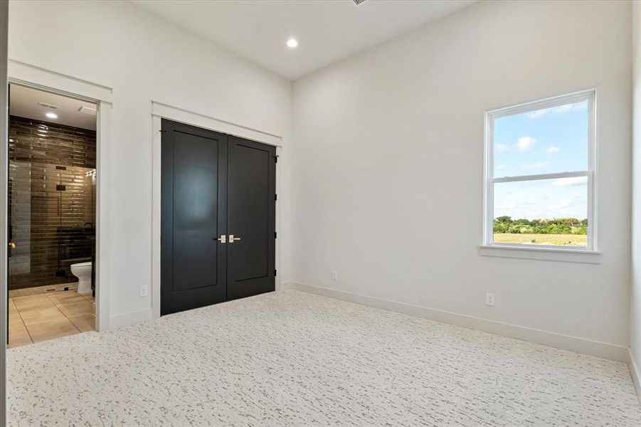 Unfurnished bedroom featuring light tile patterned floors, recessed lighting, ensuite bath, and light carpet