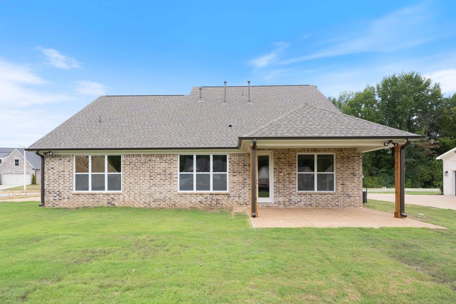 Brick exterior with a covered patio, multiple windows, and a shingle roof Brick exterior with a covered patio, multiple windows, and a shingle roof