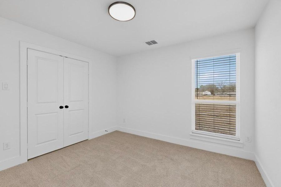 Unfurnished bedroom featuring light colored carpet and a closet