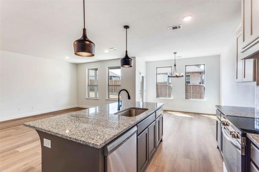 Kitchen with a sink, stainless steel appliances, light wood-style flooring, baseboards, and recessed lighting