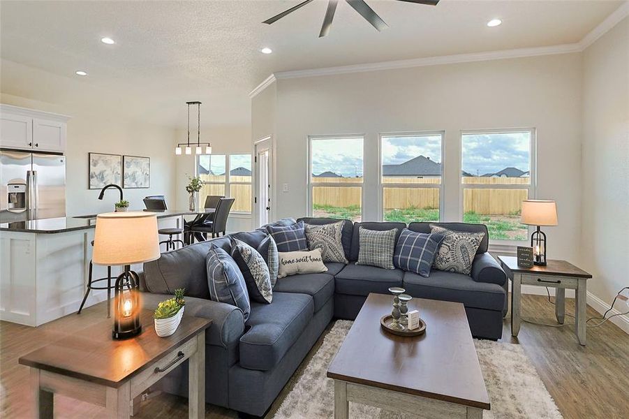 Open-concept living space featuring vaulted ceilings, recessed lighting, and wood-finish flooring