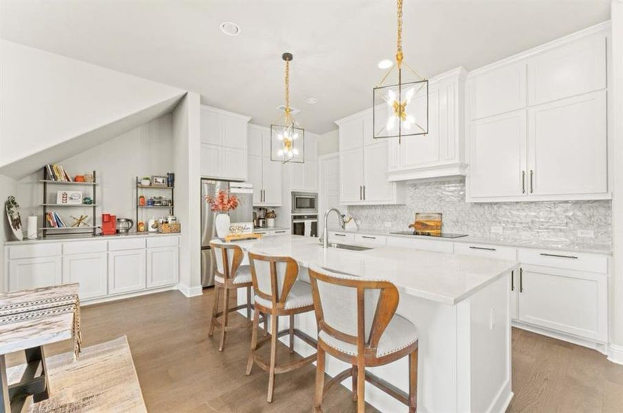 Kitchen with a notable chandelier, light wood-type flooring, sink, and stainless steel appliances