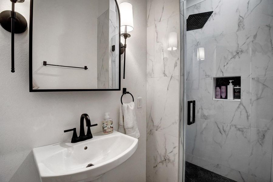 Full bath with a marble finish shower Full bath with a marble finish shower