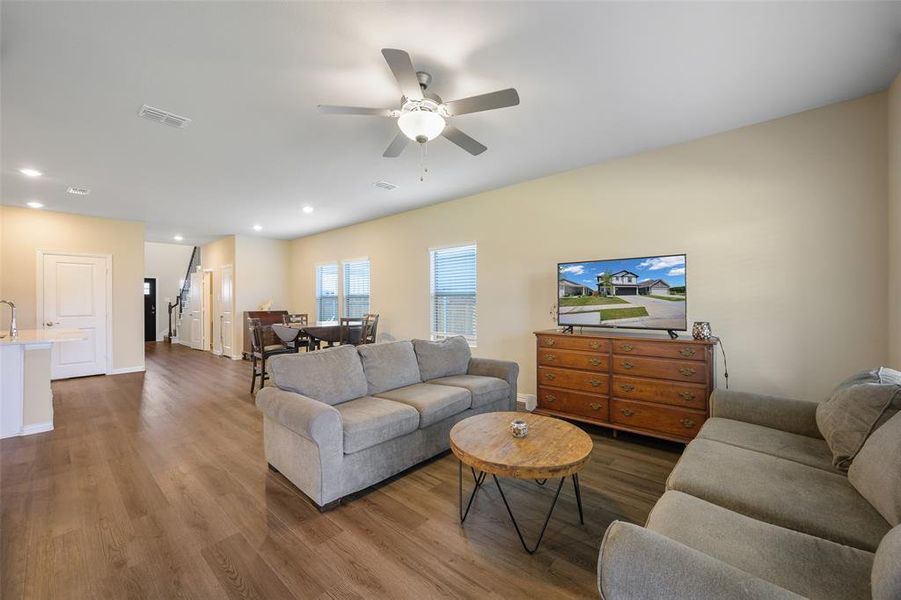Expansive open-concept living space featuring wood-finish flooring, recessed lighting, and a ceiling fan Expansive open-concept living space featuring wood-finish flooring, recessed lighting, and a ceiling fan