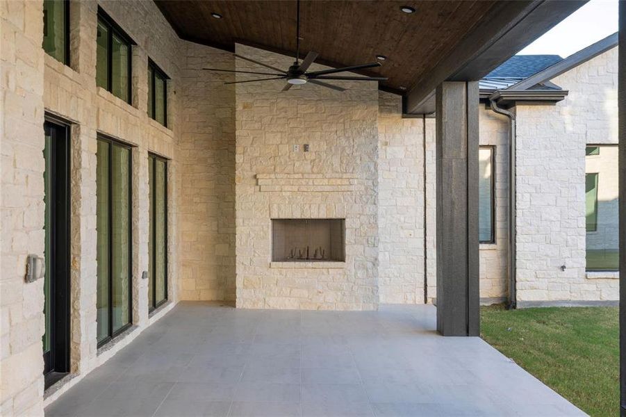 View of patio / terrace featuring an outdoor stone fireplace and a ceiling fan View of patio / terrace featuring an outdoor stone fireplace and a ceiling fan