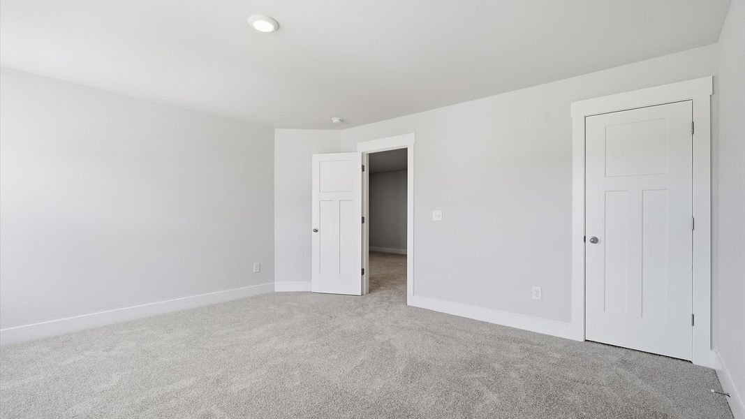 Inviting bedroom with tasteful finishes and large windows that create a fresh, open ambiance