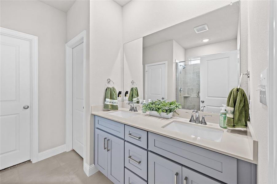 This spa-like primary bathroom is a true builder upgrade, featuring a spacious double vanity with dual sinks and an abundance of cabinetry—including a highly functional center bay of drawers for extra storage. The owners thoughtfully opted for maximum luxury by selecting an oversized, extra-large walk-in shower in place of a traditional tub, creating a sleek, open, and modern retreat.