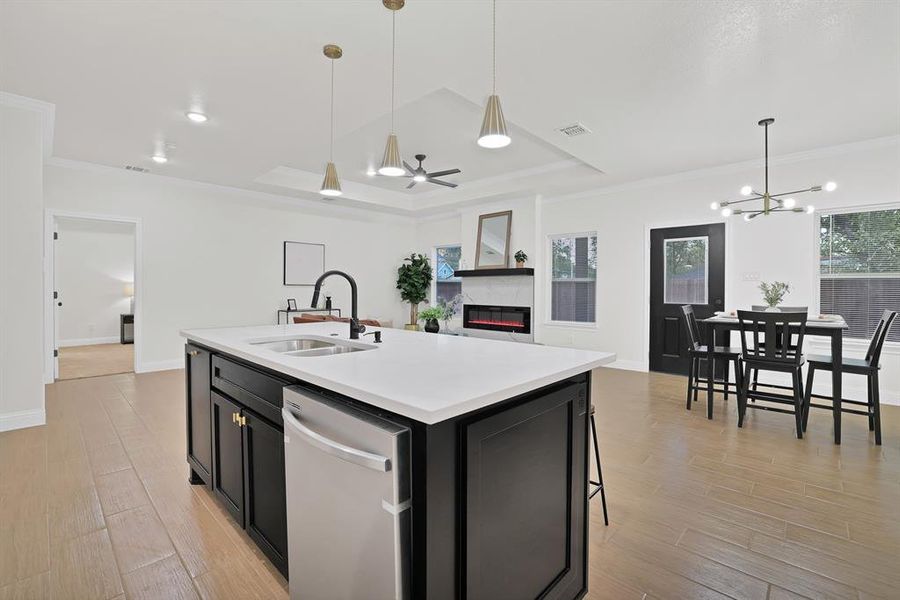 Kitchen with a kitchen island with sink, dishwasher, a healthy amount of sunlight, and sink