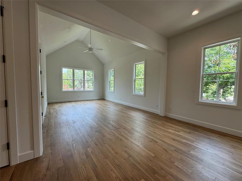 Spare room featuring hardwood / wood-style flooring, lofted ceiling, and ceiling fan