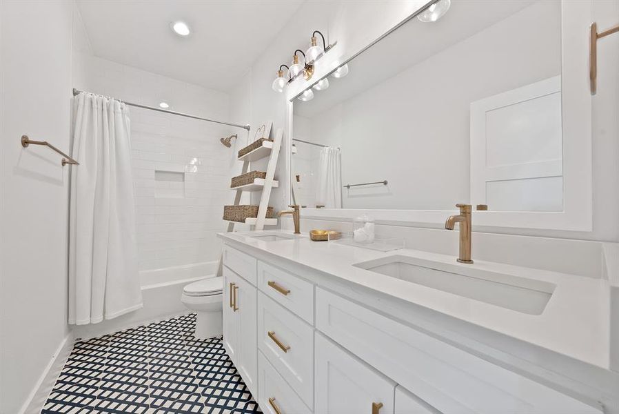 Modern bathroom featuring a dual vanity with integrated sinks, white cabinetry, and brushed gold hardware Modern bathroom featuring a dual vanity with integrated sinks, white cabinetry, and brushed gold hardware
