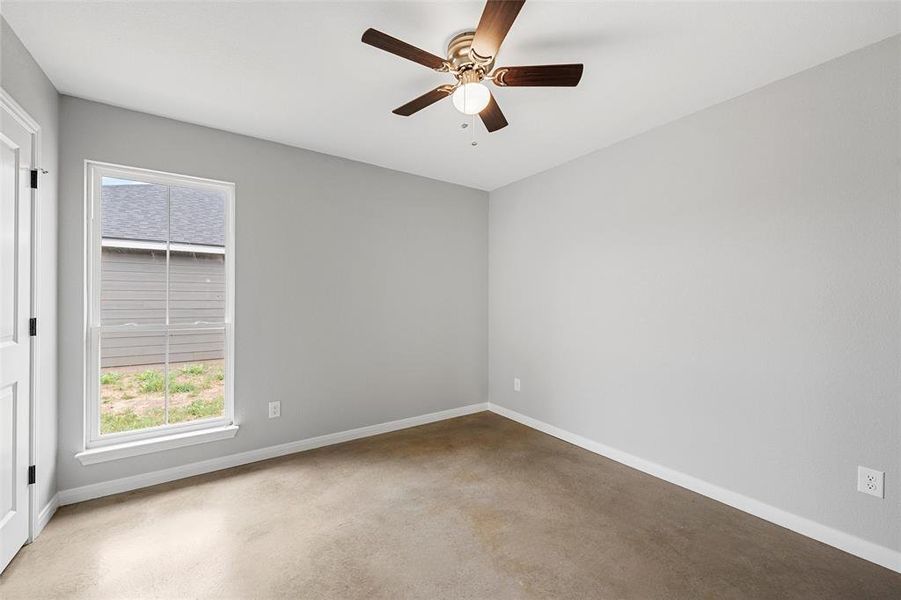 Empty room featuring ceiling fan and baseboards