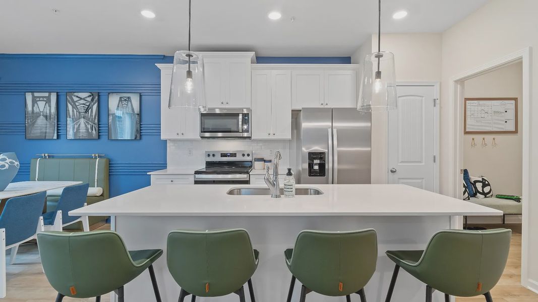 Modern kitchen with quartz island, stylish backsplash, stainless steel  appliances, and ample cabinet storage in Auburn Ridge