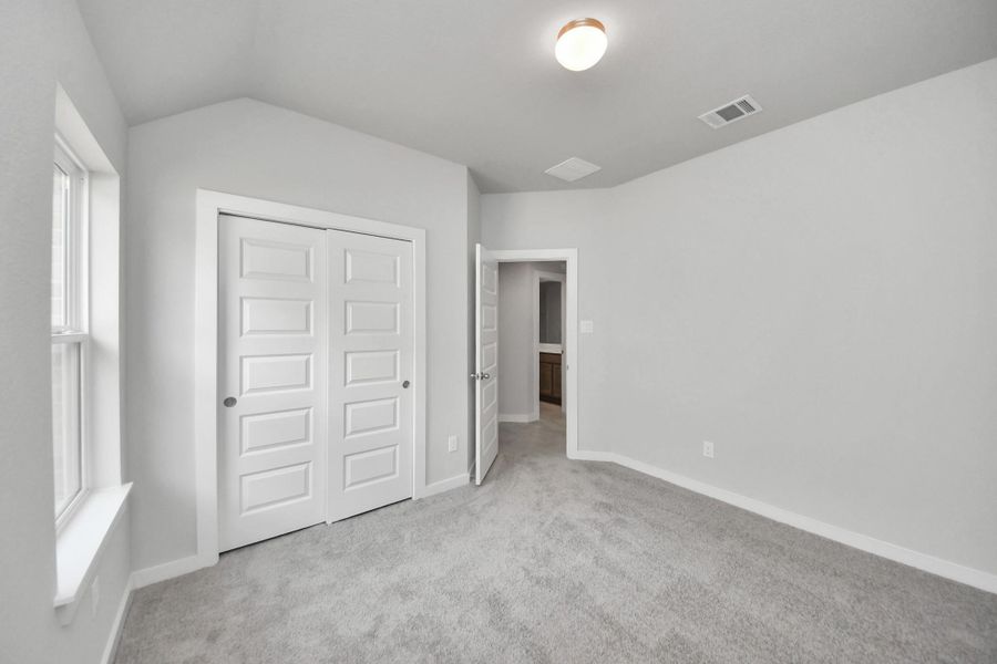 Generously sized secondary bedrooms featuring spacious closets, soft and inviting carpeting underfoot, large windows allowing plenty of natural light, and the added touch of privacy blinds for your personal retreat. Sample photo of completed home with similar floor plan. Actual colors and selections may vary.