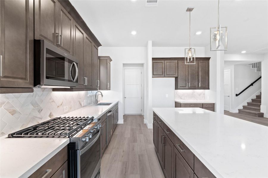 Welcome to the heart of the home, a modern, highly functional kitchen that perfectly balances style and utility. Quartz countertops, complemented by a stylish backsplash, shaker-style cabinets provide ample storage, and the Whirlpool stainless steel appliances are all features of this beautiful kitchen!