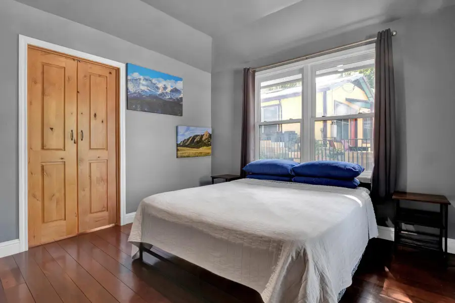 Bedroom with dark wood-type flooring and vaulted ceiling
