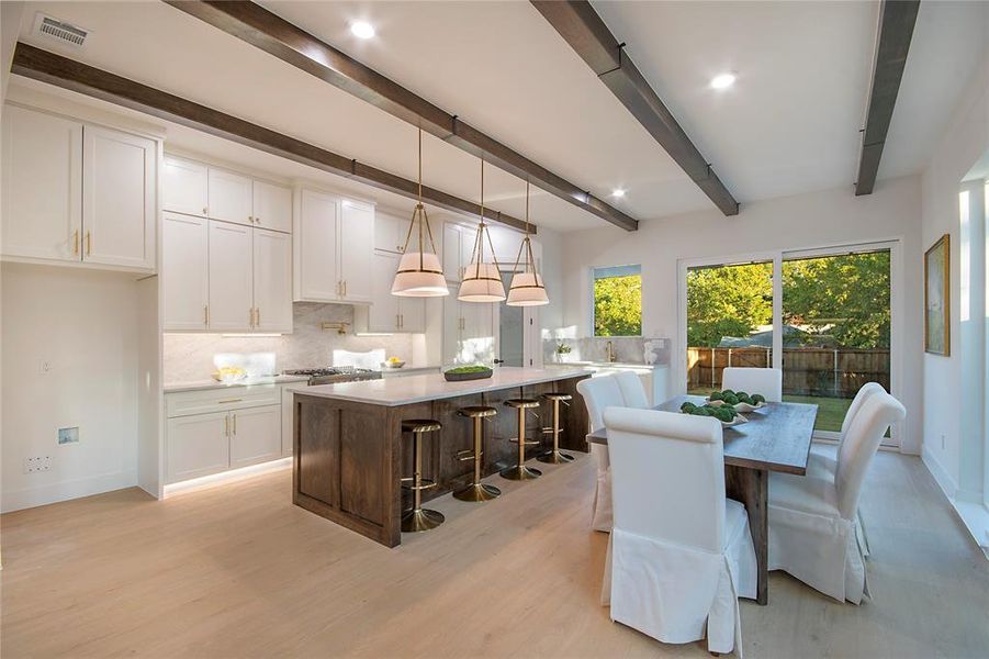 Dining space with beam ceiling, light wood-style floors, and recessed lighting