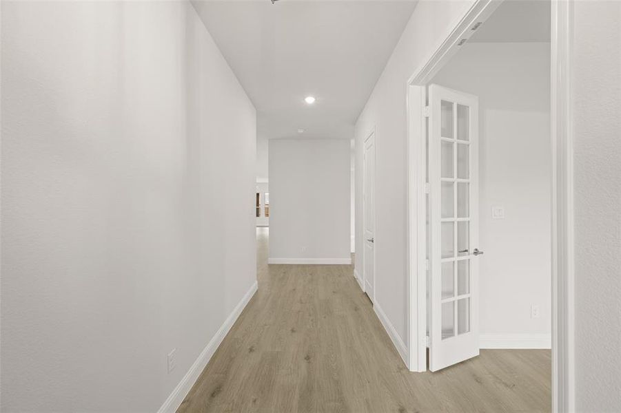 Corridor featuring light wood-style flooring and recessed lighting