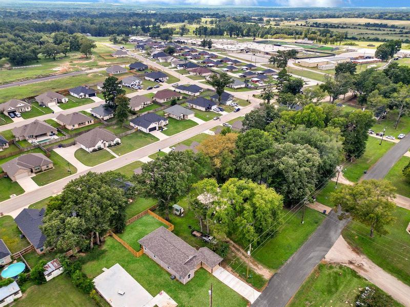 Aerial view of property and surrounding area featuring nearby suburban area and a tree filled landscape Aerial view of property and surrounding area featuring nearby suburban area and a tree filled landscape