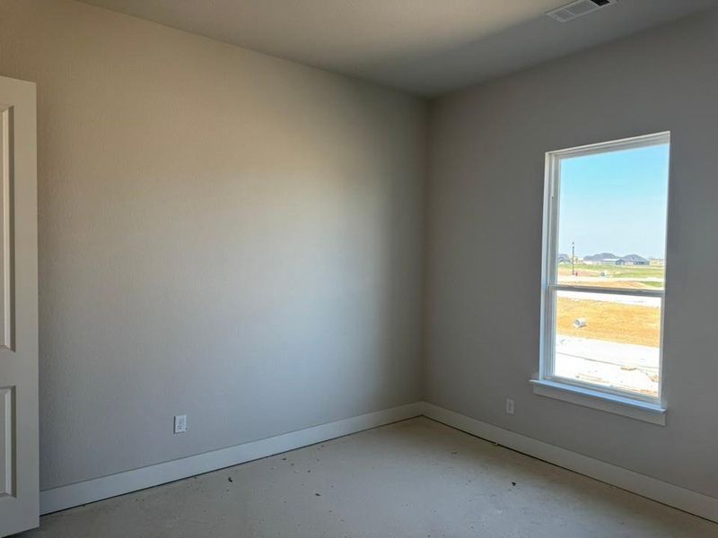 Empty room featuring baseboards and concrete flooring