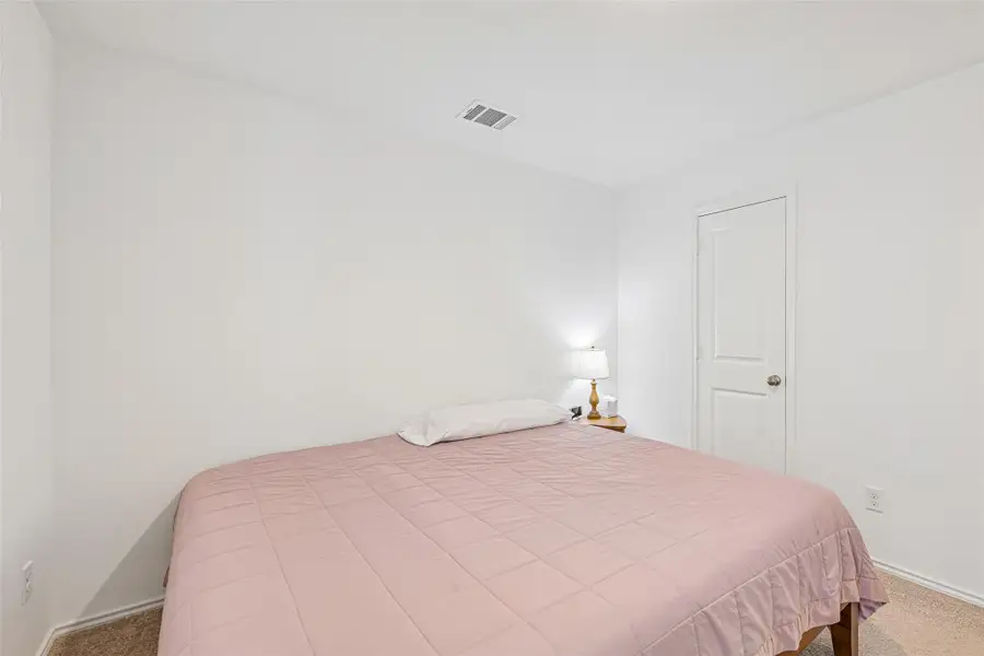 Neutral wall paint with carpet flooring and a solid panel interior door Neutral wall paint with carpet flooring and a solid panel interior door