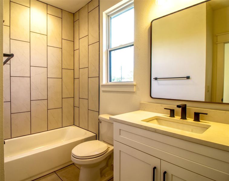 Full bath with  shower combination, vanity, and tile patterned floors
