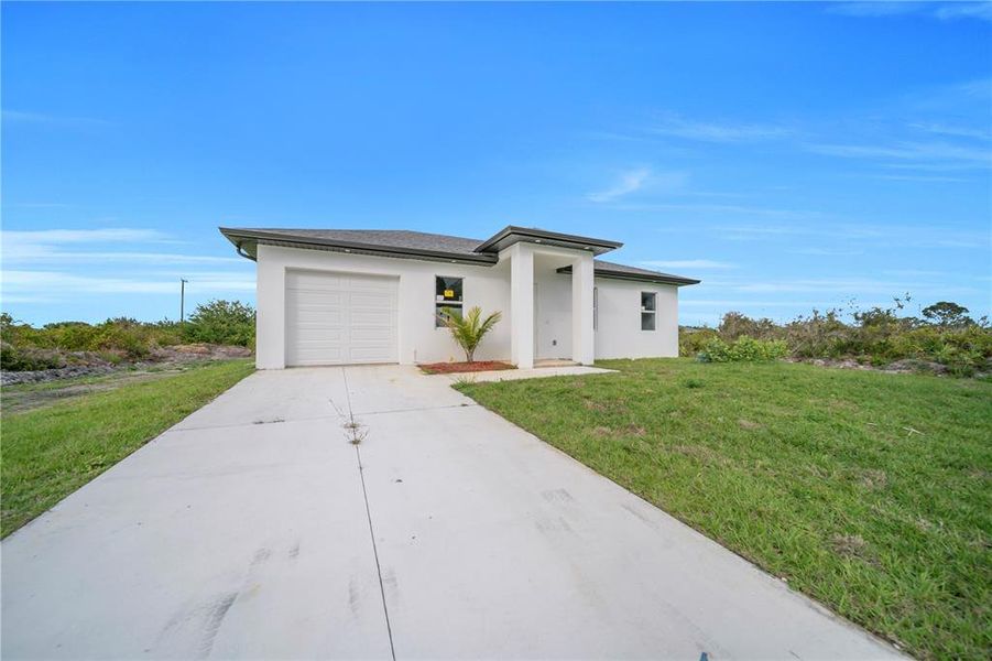 Front exterior of a new home in , Lehigh Acres, FL, highlighting curb appeal (Image 24).