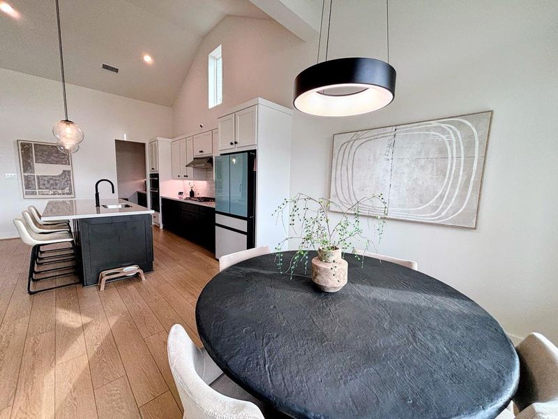 The dining area features a large windows offering a scenic outdoor view