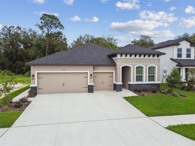 Front exterior of a new home in Hidden Ridge, New Port Richey, FL, highlighting curb appeal (Image 24).