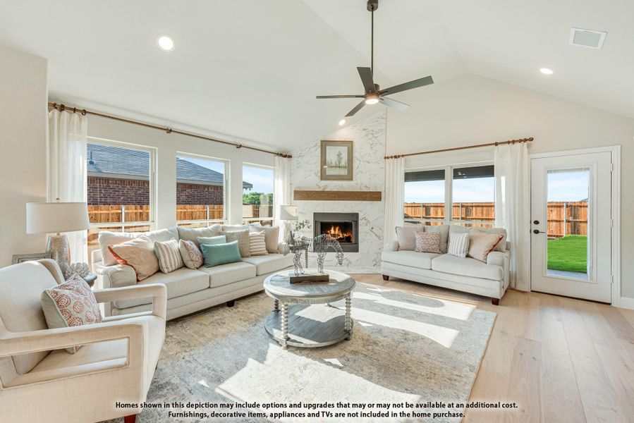Living room with vaulted ceiling, marble fireplace, ceiling fan, and hardwood floors Living room with vaulted ceiling, marble fireplace, ceiling fan, and hardwood floors