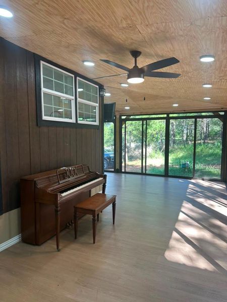 A spacious room offers an inviting atmosphere with natural wood finishes and forest views.