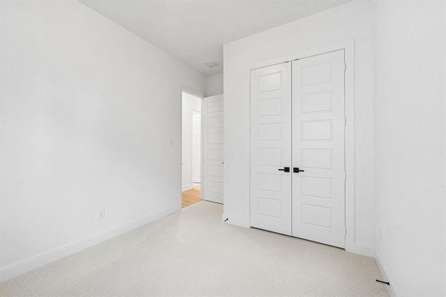 Unfurnished bedroom featuring light colored carpet and a closet Unfurnished bedroom featuring light colored carpet and a closet