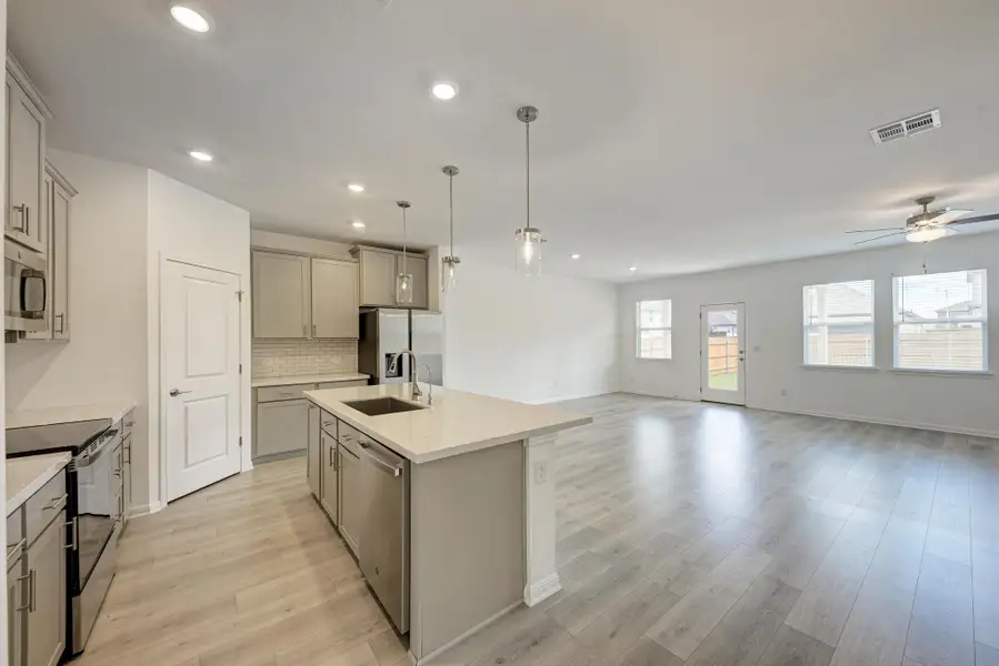 An open-concept design seamlessly connects a well-appointed kitchen to a spacious living area.