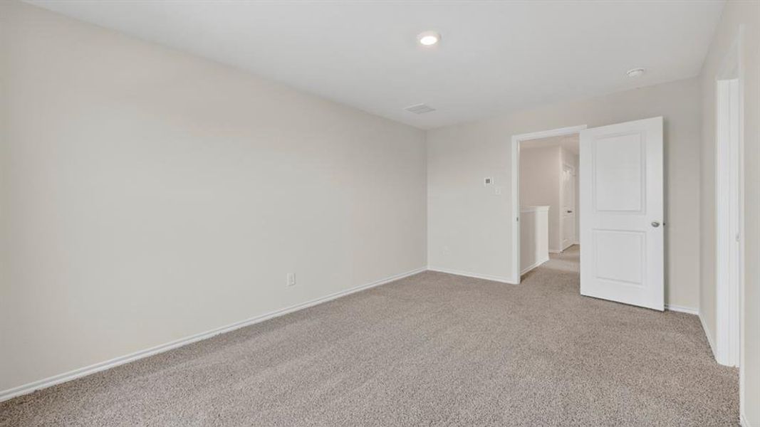 Neutral-toned room featuring light gray carpeting, white trim, and a recessed ceiling light
