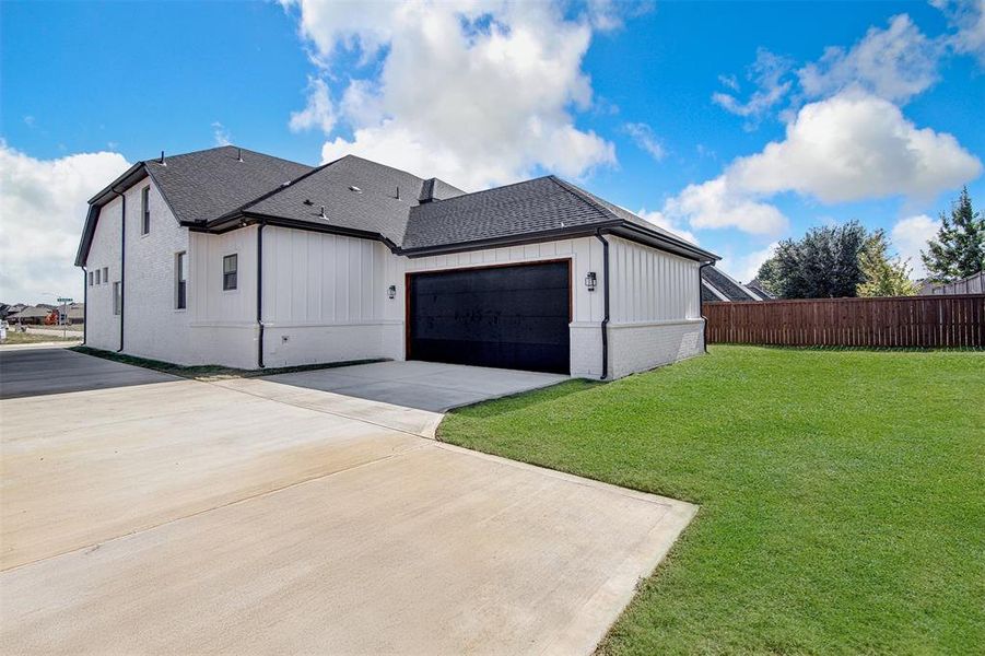 View of side of property featuring roof with shingles, concrete driveway, brick siding, and an attached garage. View of side of property featuring roof with shingles, concrete driveway, brick siding, and an attached garage.